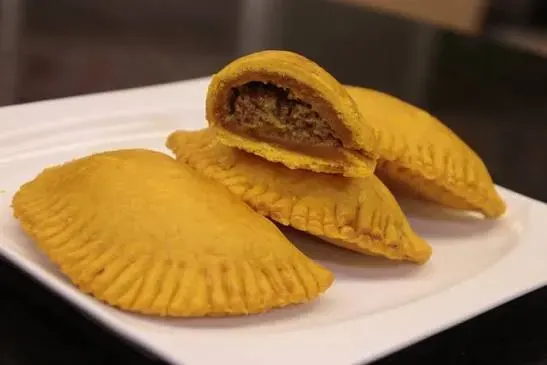 Pati abierto que muestra su relleno de carne molida sazonada.