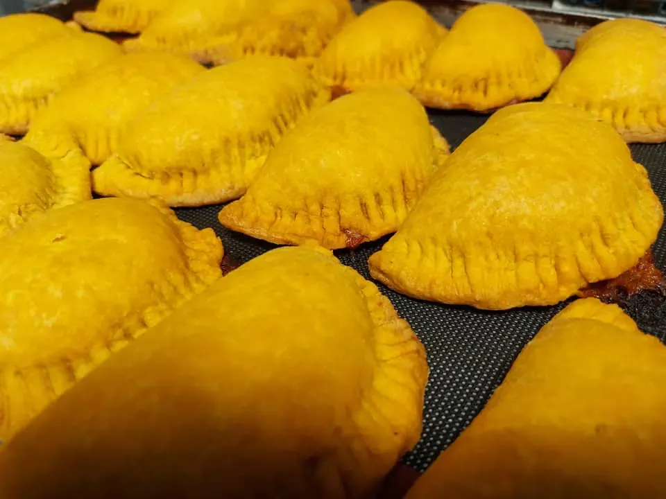 Bandeja de patis dorados recién salidos, con su borde repulgado.