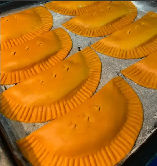 Plantintas de masa de plátano maduro, de color naranja, sobre una bandeja.
